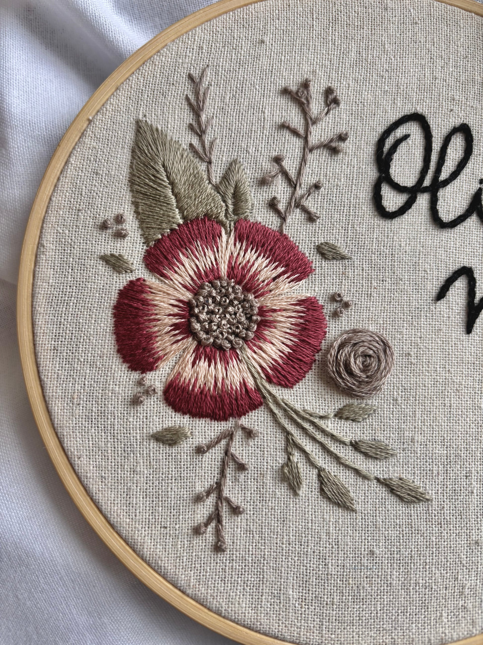 Porta alianzas hecho a mano en bastidor de madera, bordado floral con hilo de algodón y acabado rústico para boda.