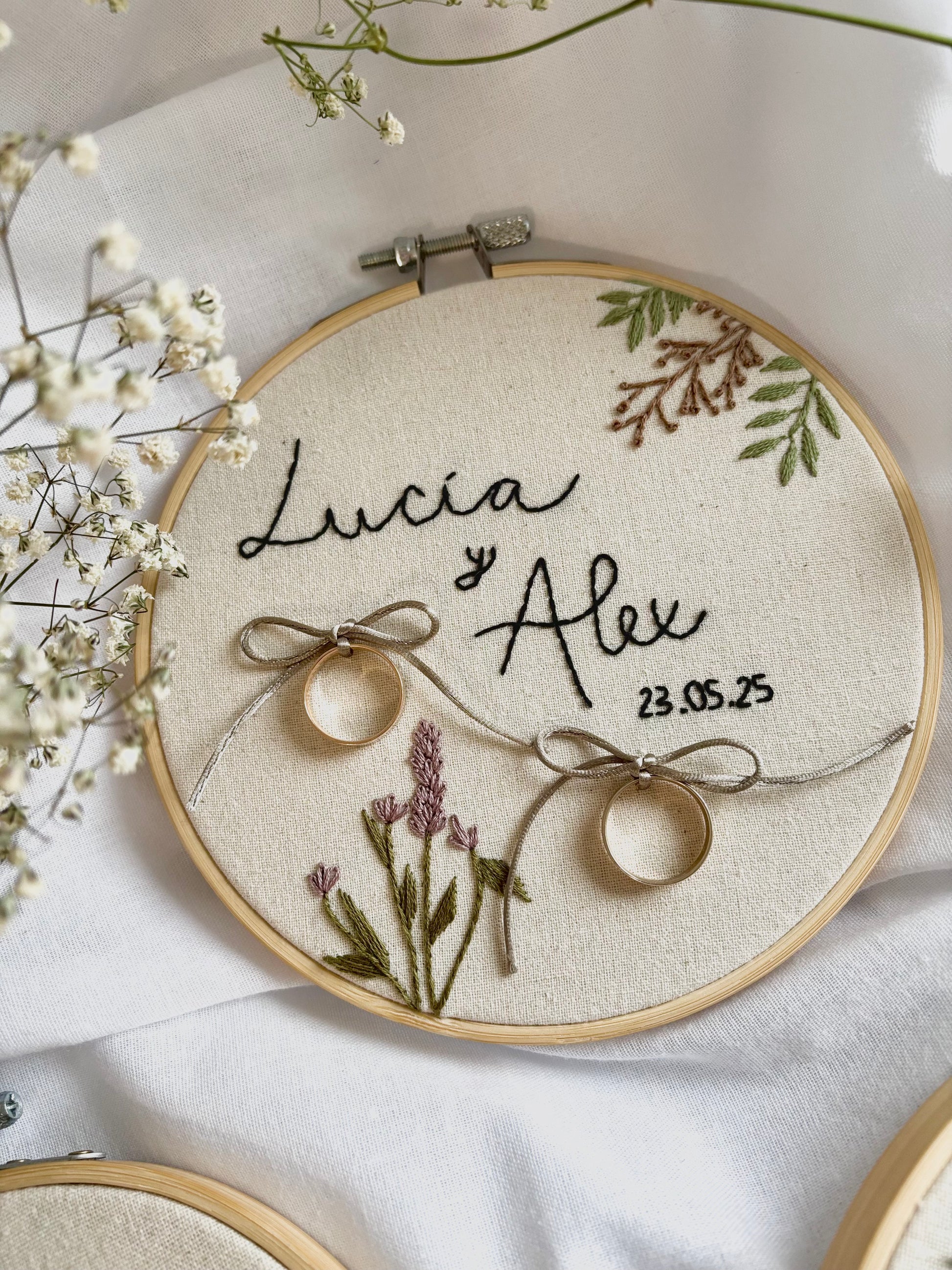 Bastidor porta alianzas para boda bordado a mano, diseño floral delicado en algodón, estilo boho y romántico.