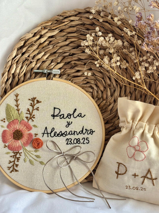 Detalle de boda bordado a mano: pack de porta alianzas y saquito de arras con motivos florales, estilo boho, diseño rústico y personalizado para boda única.