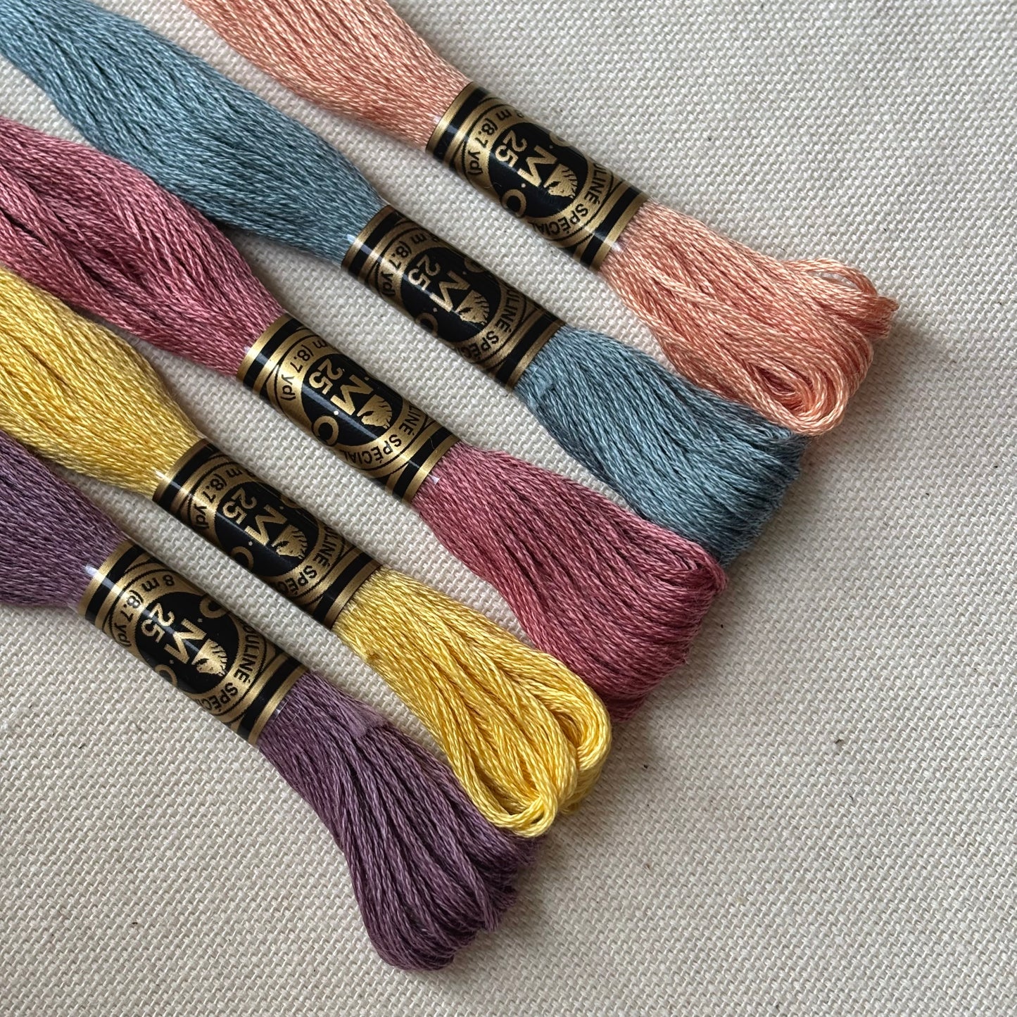 Selección de hilos para bordar en colores suaves tipo pastel, perfecta para proyectos de bordado a mano. Estos hilos mouliné DMC son ideales para kits de bordado, patrones delicados y material de bordado para principiantes.