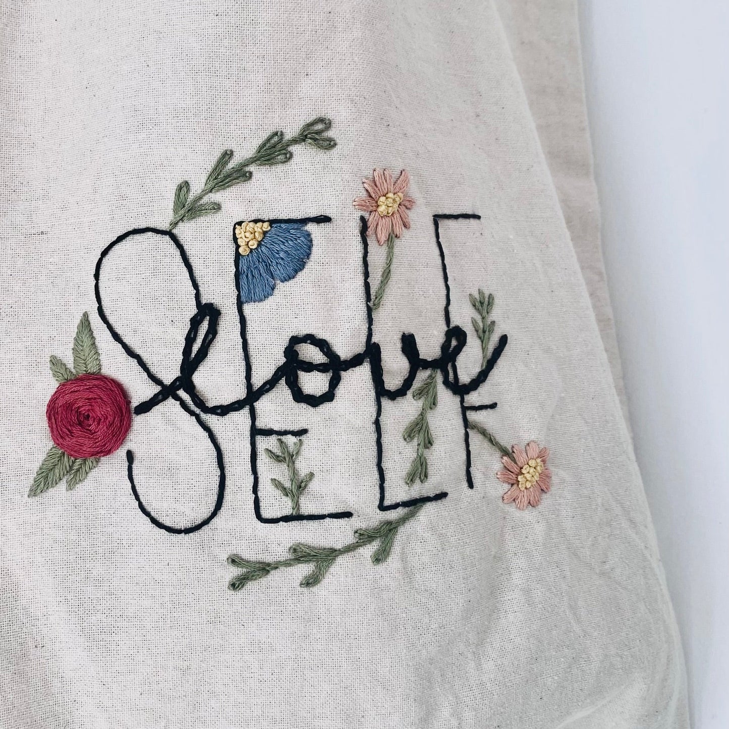 Patrón de bordar para descarga digital con diseño de bordado floral y frase self love. Personaliza accesorios y prendas de vestir con proyectos upcycling utilizando patrones digitales para bordar a mano.