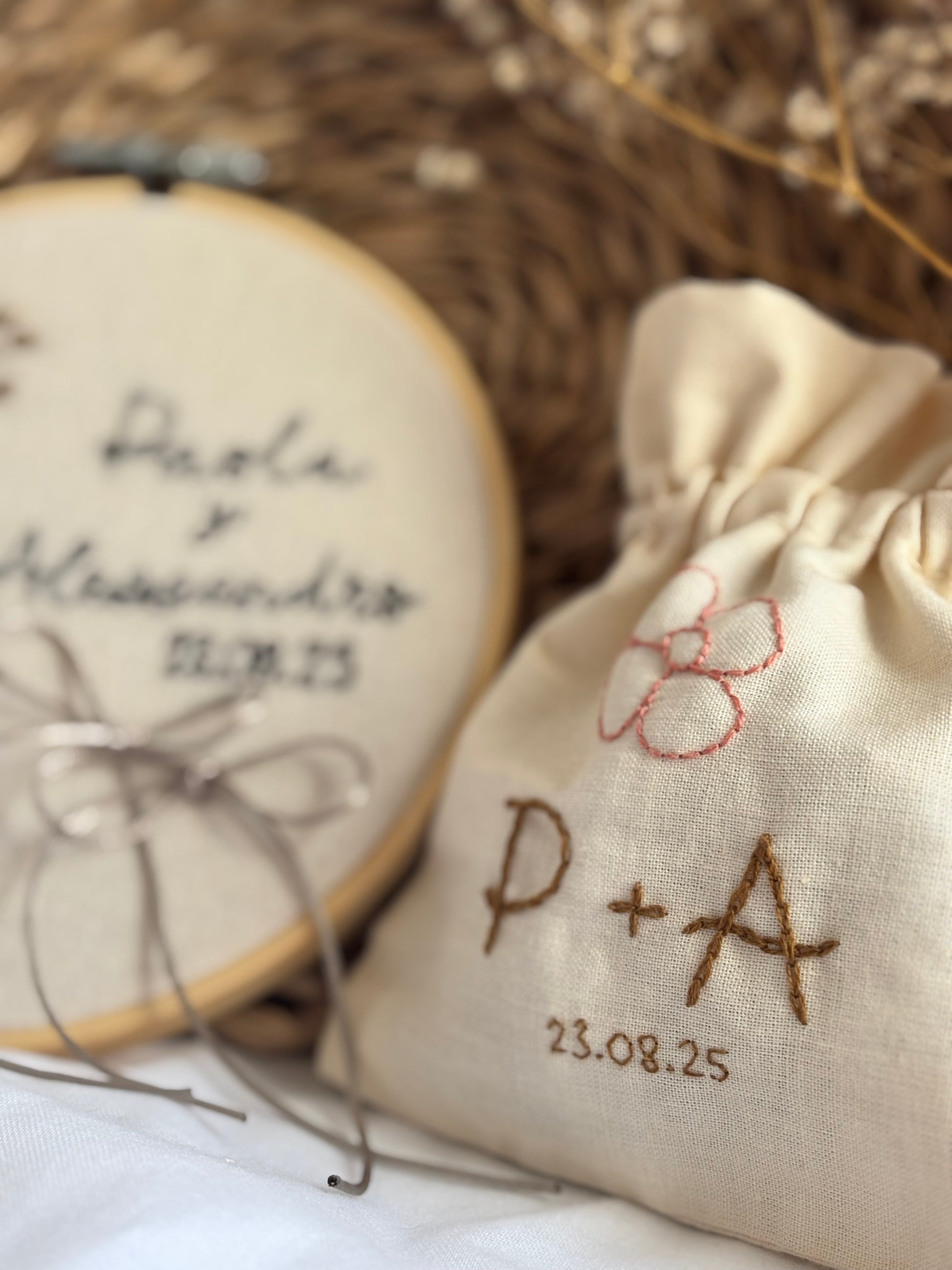 Detalle de boda bordado a mano: pack de porta alianzas y saquito de arras con motivos florales, estilo boho, diseño rústico y personalizado para boda única. Hecho a mano en España